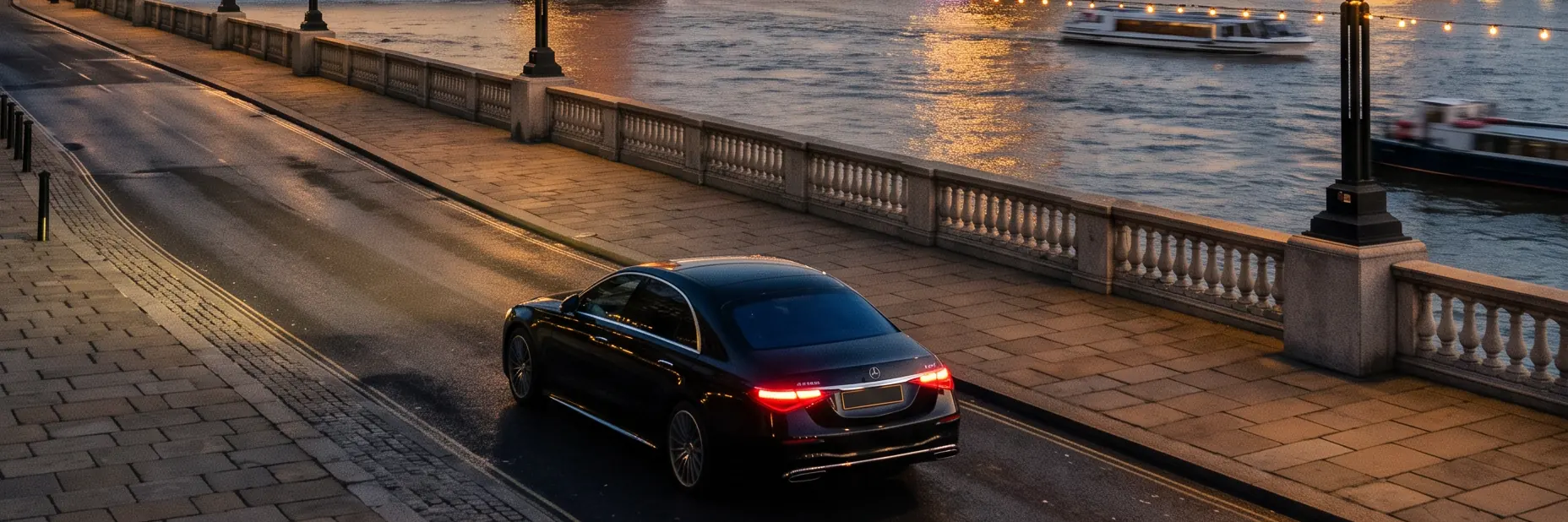 Black Mercedes on the Thames embankment with Tower Bridge at golden hour